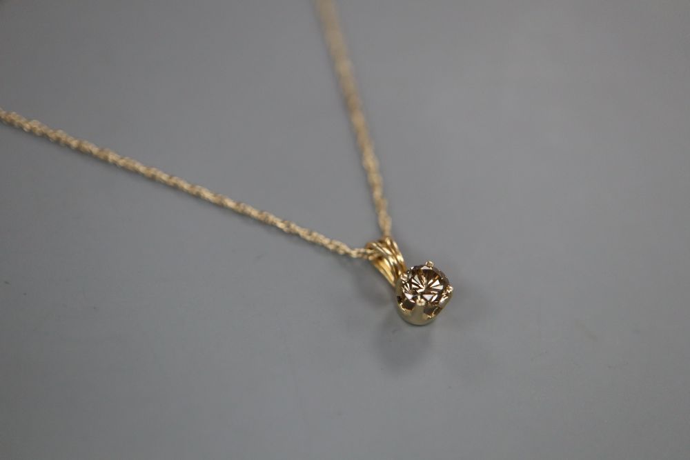 A 10k and chocolate coloured round brilliant cut solitaire diamond pendant, on a 10k fine link chain.